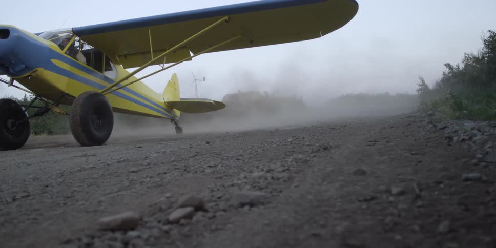 A plane is moving downhill on a dirt road