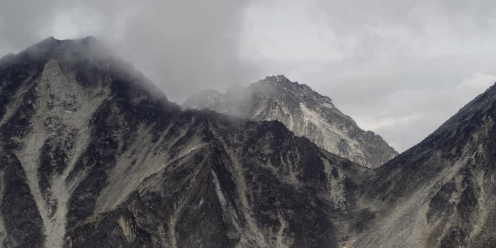 Aerial view of cloud-covered, snow-capped mountains