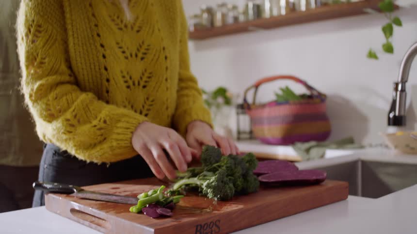 A man and woman are preparing food in the kitchen