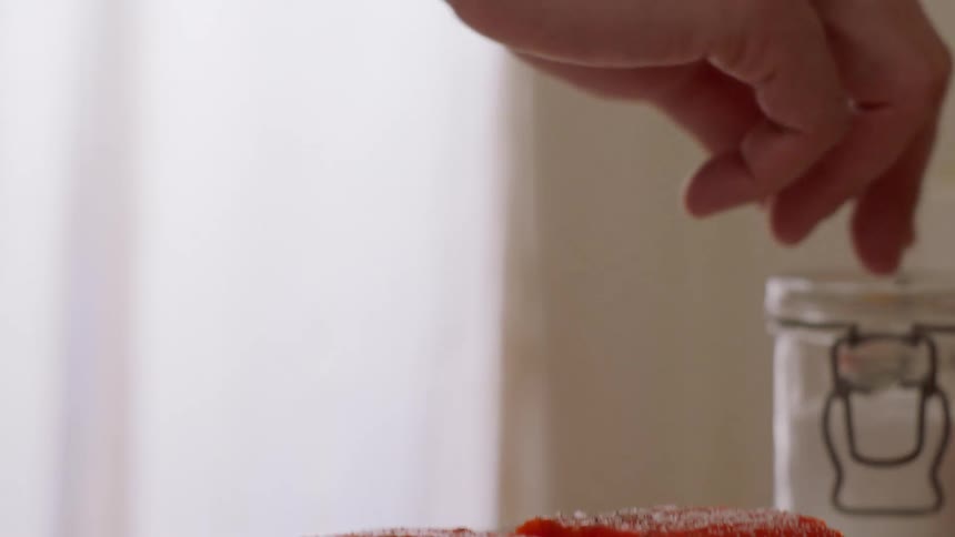 Salt is sprinkled on two pieces of salmon