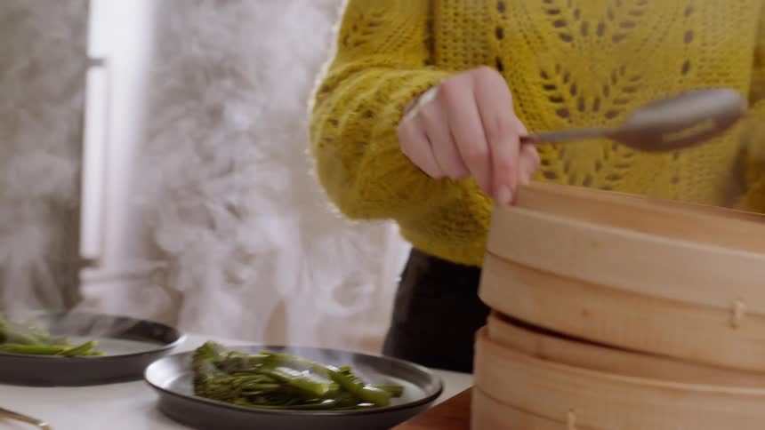 A white woman puts greens and meat on plates