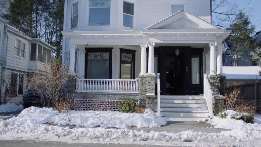 A person opening the front door of a house then walking in