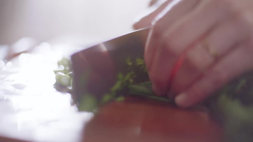Chopping up green onion on cutting board
