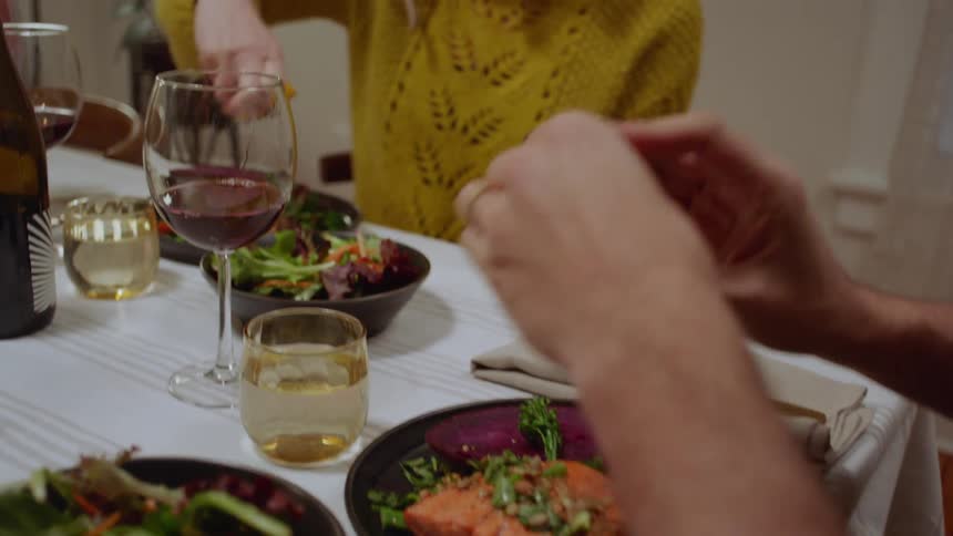 A white woman and white man sit at a table and eat a meal