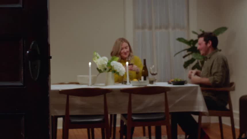 Man and woman enjoy a romantic dinner with candles and wine