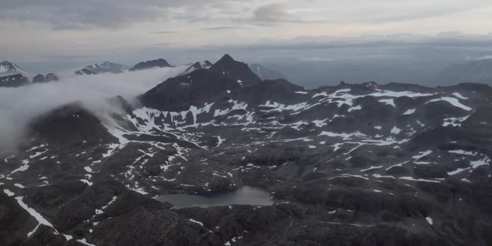 Tall snow covered mountains with a bank of fog moving over them