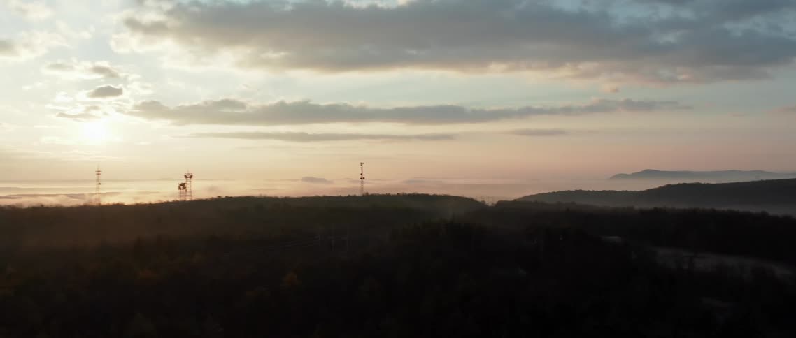 Several towers and antennas dot a nature landscape