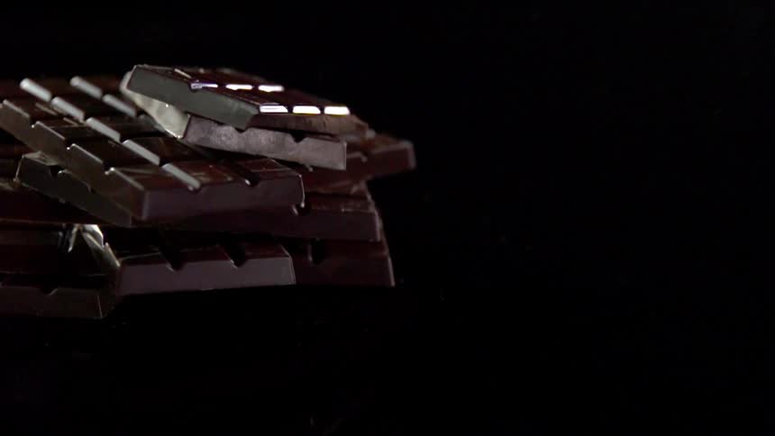 Bars of chocolate drop on a pile