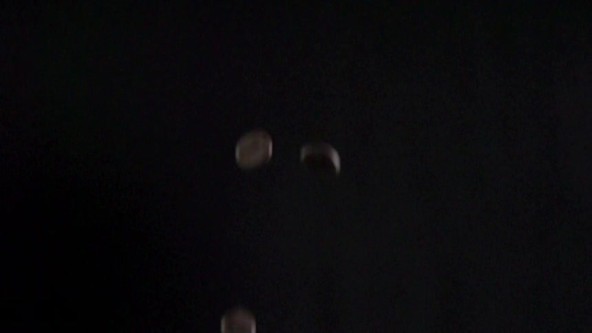 Whole raw coffee beans slowly fall down