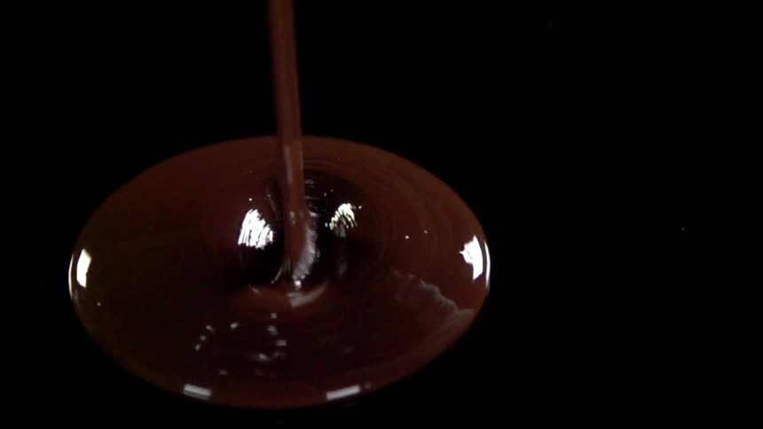 Poured chocolate pools on the top of a black table
