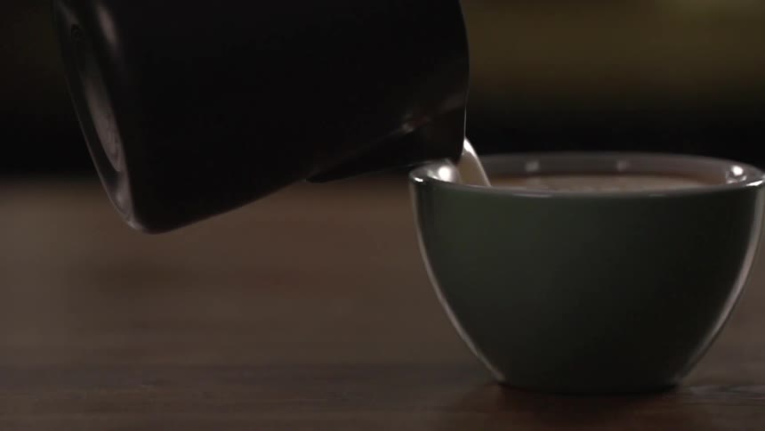 A drink being poured in a to a mug