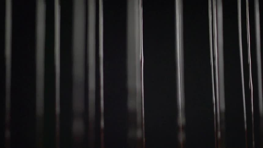 Parallel dividers move downward shining against black