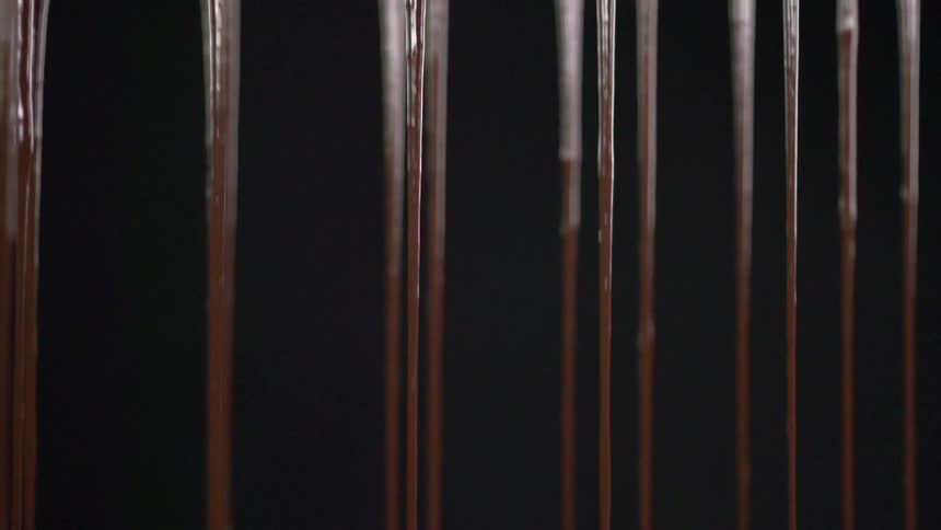 Strings of chocolate pour downwards