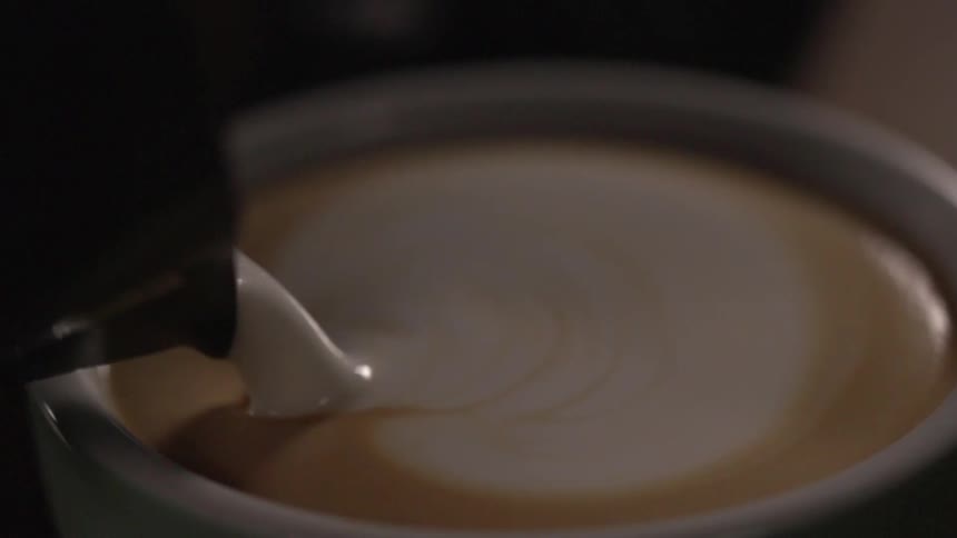 Cream being poured into coffee