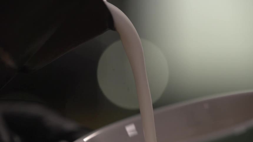 Pouring latte into a coffee cup