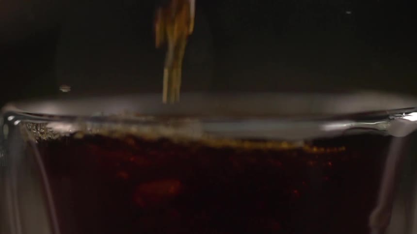 A dark fluid fills a glass