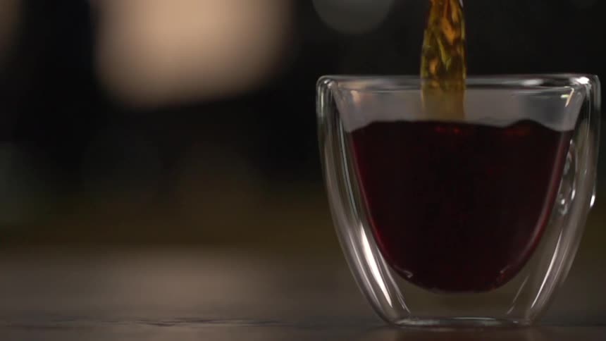 A drink being poured in to a glass in a studio