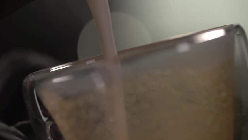 Brown cream liqueur pouring into small glass