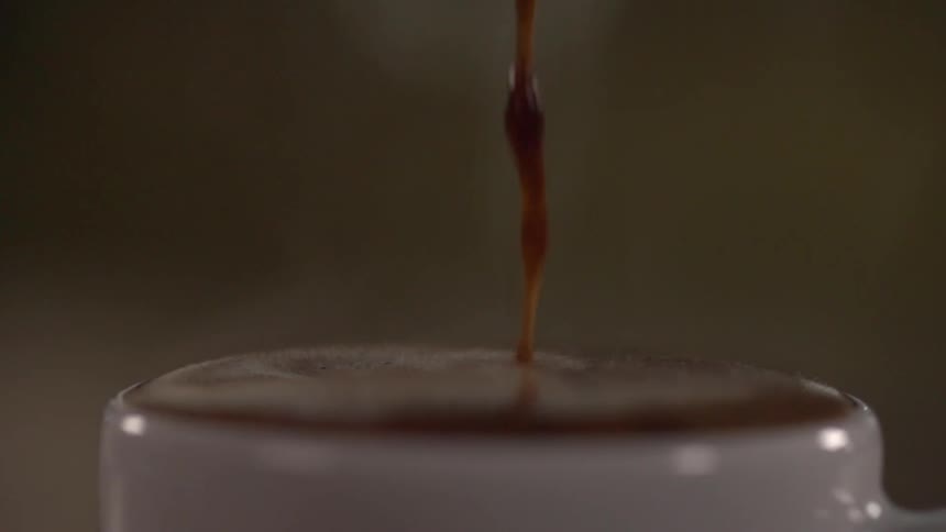 Hot coffee being poured on a cup in slow motion