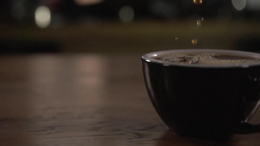 Coffee pours into a mostly full cup