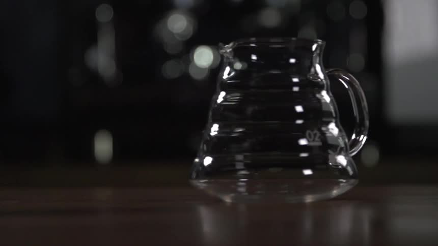 A glass pitcher sits on a wood surface