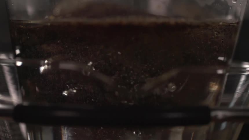 Ground coffee poured on water inside a percolator