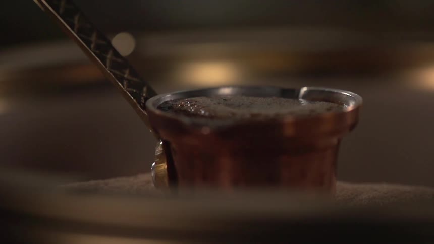 A ladle filled with a foamy liquid sits on a table