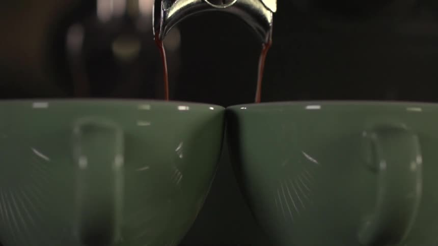 Liquid coffee is being poured into a cup