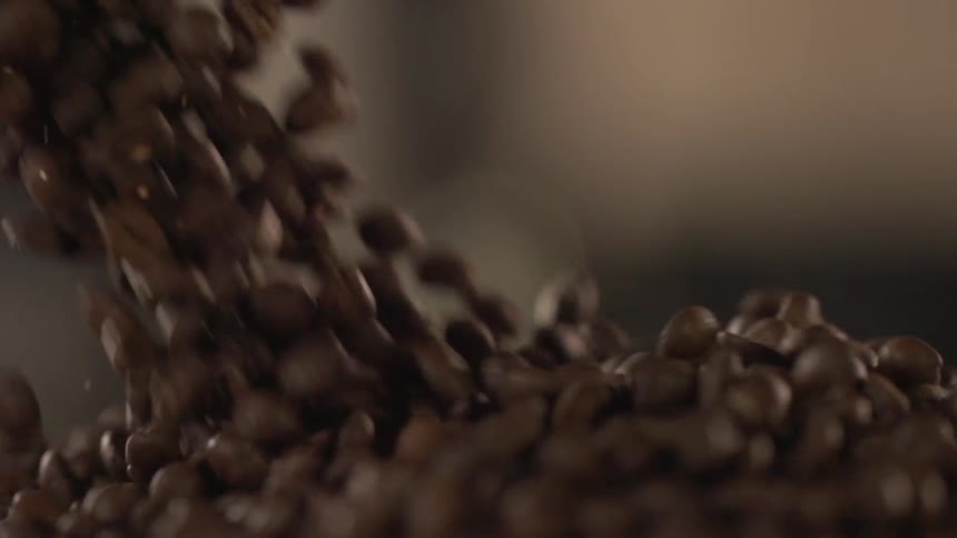 Coffee beans spill into a big pile