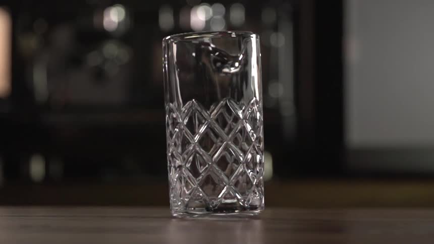 A glass pitcher spins on a table top
