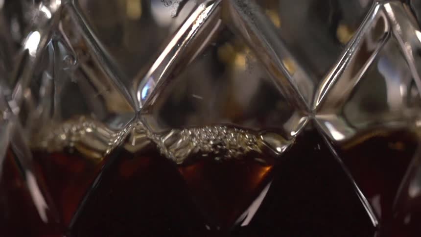 Dark brown drink in carved drinking glass