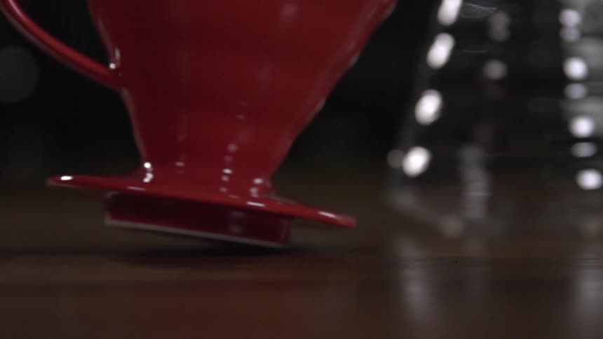 Red coffee mug spins in slow motion on tabletop