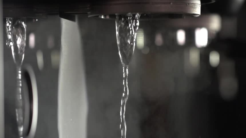 Two streams of water flow as steam rises around them