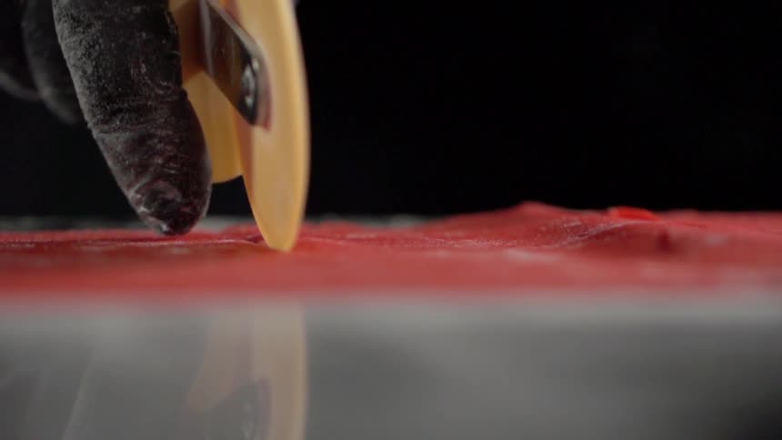 A person cuts pasta dough