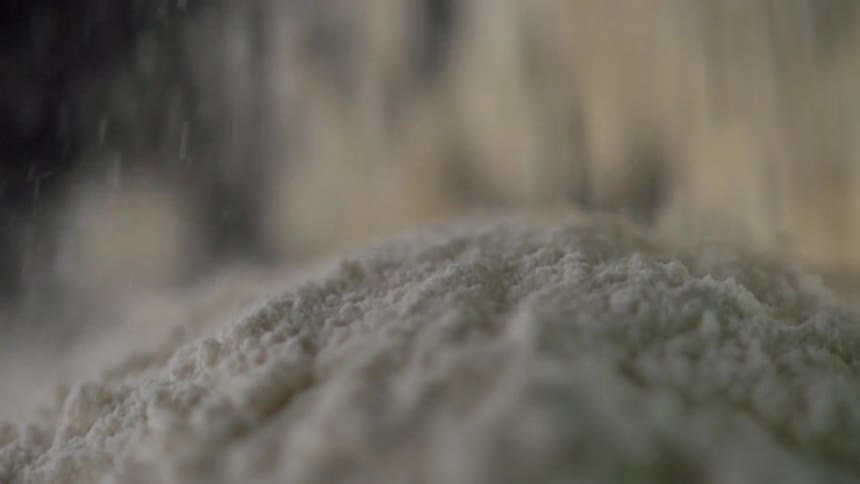 White powder dropping with a black background