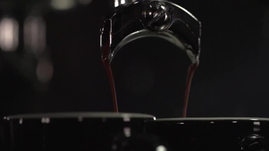 Coffee being dispensed from a machine in to cups