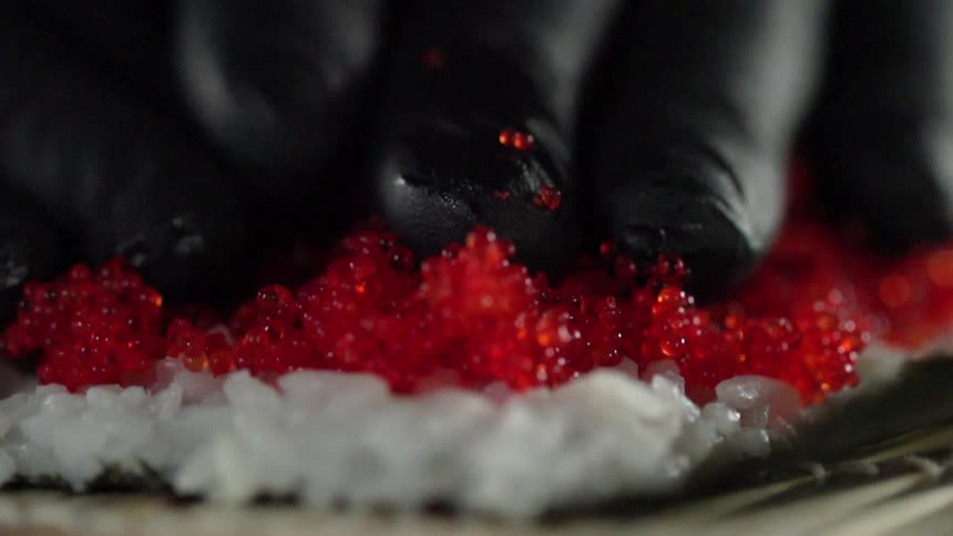 Roe is spread on a sushi wrap by hand