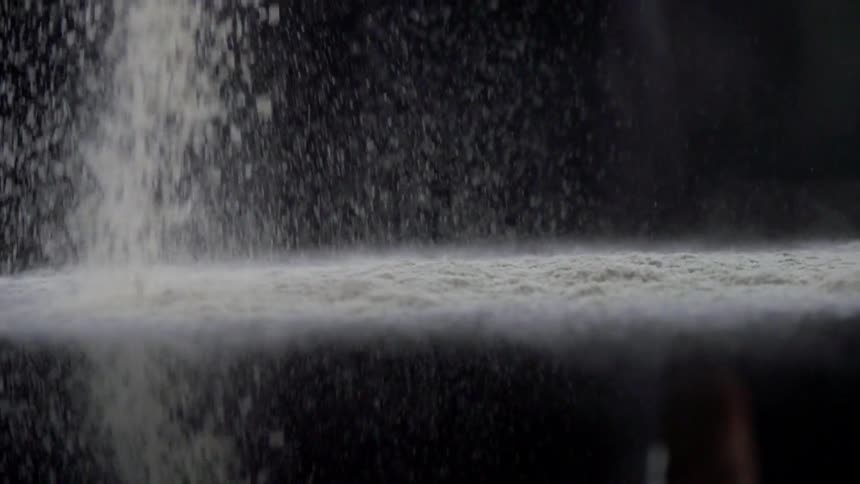 Flour is poured on a black table