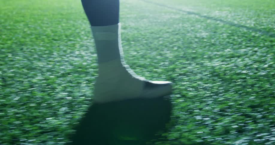 A football player runs down a field