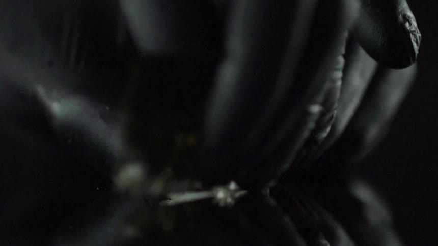 Close up of gloved hands wrapping a sushi roll