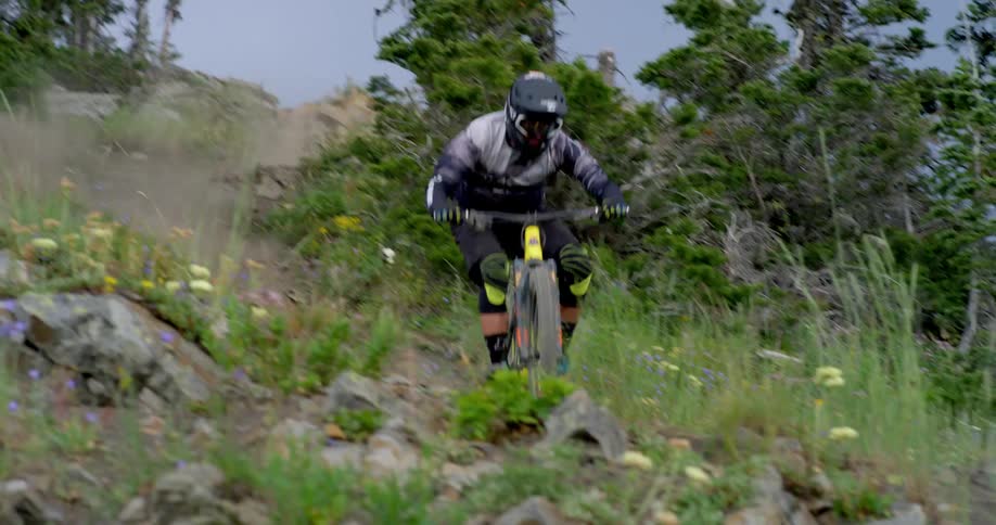 A mountain bike rider descends a steep trail in the alpine