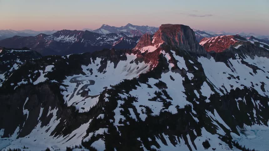 Rugged snow covered mountain range at sunset