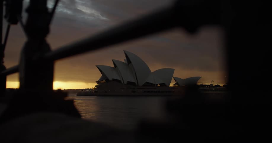 A boat sails by the sydney opera house