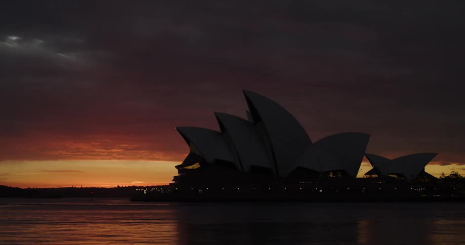 Ships cross paths in front of sydney opera house as sky lightens