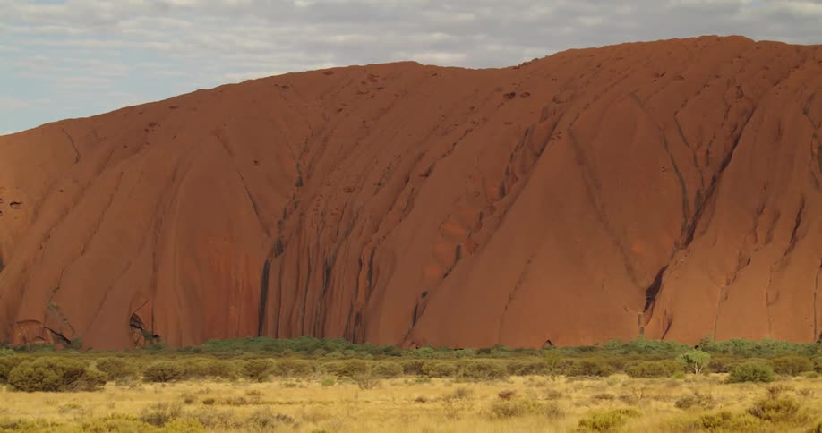 Sun moves over Uluru rock in outback desert