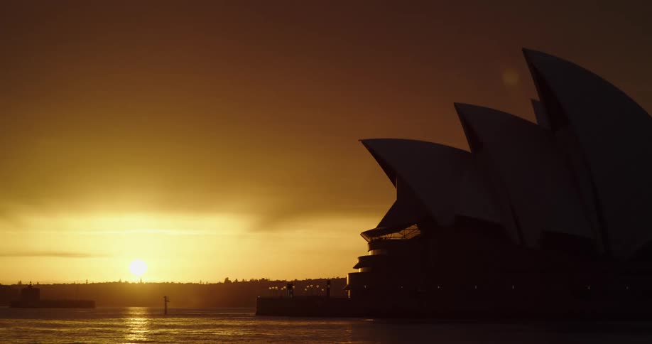 Sydney opera house silhouetted against sunrise