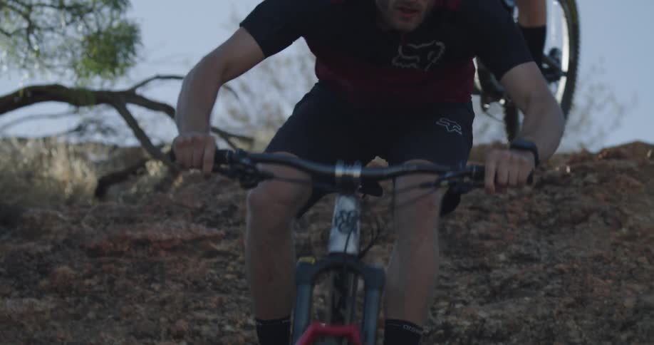 Man and woman are riding mountain bikes down rock roll
