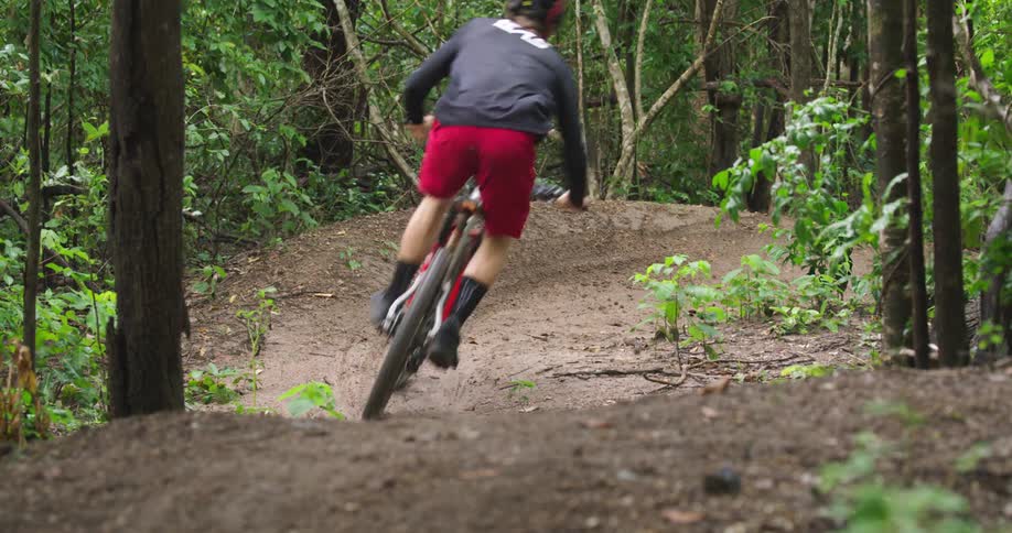 A mountain biker races through a dirt corner on a trail