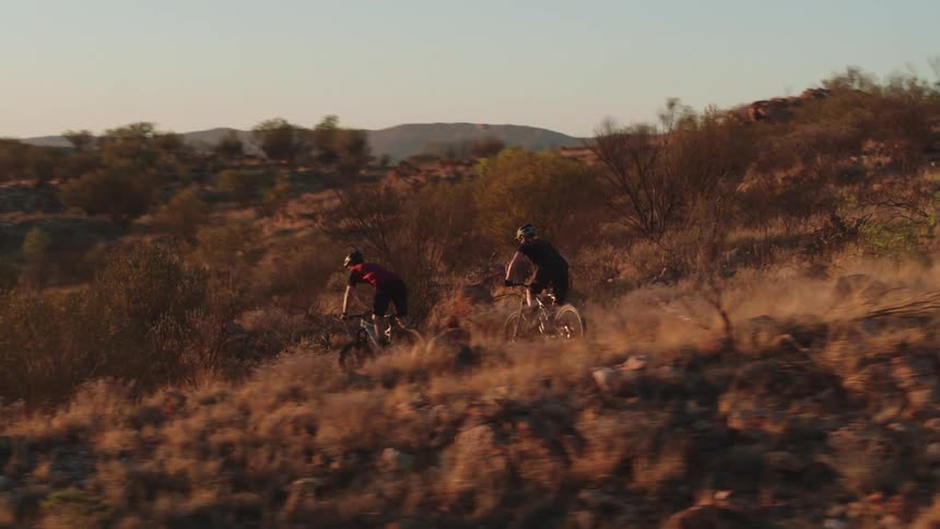 Man and woman mountain biking in a desert nature area