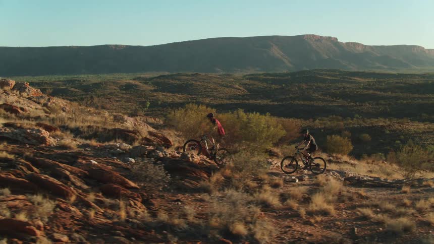 A man and woman cycle up a hill
